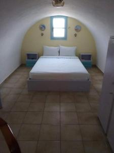 1 dormitorio con 1 cama grande en una habitación en DARZENTA ATHINA BEACH HOUSES, en Perivolos