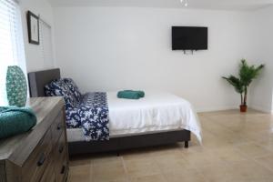 a bedroom with a bed and a flat screen tv at Singer Island Inn/ Deluxe Studio in West Palm Beach
