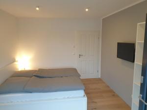 a bedroom with a bed and a flat screen tv at Willkommen zu Hause, ankommen & wohlfühlen ! in Tremsbüttel