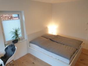 a small bed in a room with a window at Willkommen zu Hause, ankommen & wohlfühlen ! in Tremsbüttel