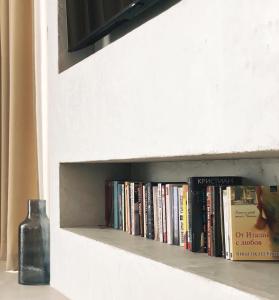 un estante de libros con libros y una botella. en Cabo Villas en Arapya