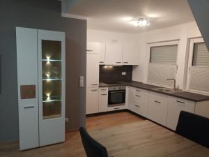 a kitchen with white cabinets and a black counter top at Ferienwohnungen Im Dorfe in Soltau +40 photos
