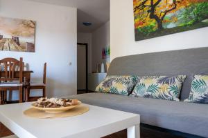 uma sala de estar com um sofá e uma mesa em Apartamento Lince em Matalascañas