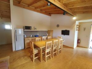 a kitchen with a table and chairs and a refrigerator at Departamentos Lonquimay in Junín de los Andes