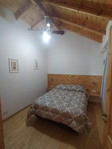 1 dormitorio con 1 cama en una habitación con techos de madera en Departamentos Lonquimay en Junín de los Andes