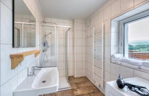 biała łazienka z umywalką i oknem w obiekcie Apartment Lannach w mieście Lannach