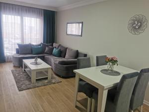 ein Wohnzimmer mit einem Sofa und einem Tisch in der Unterkunft Apartman DalMe in Novi Pazar