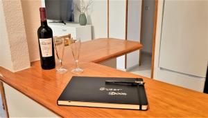 una botella de vino y un ordenador portátil en una mesa con copas en 116 COSTA BLANCA HOLIDAYS - Alicante Holiday, en La Mata