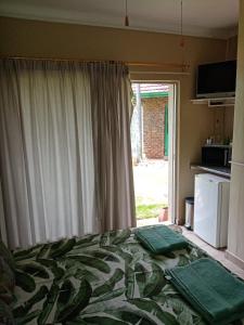 um quarto com uma cama em frente a uma janela em De la Rose Guesthouse em Lephalale