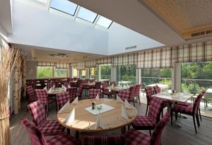 uma sala de jantar com mesas, cadeiras e janelas em Hotel Traunfall em Viecht