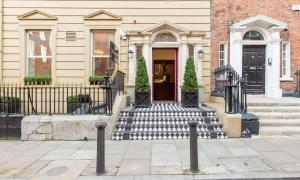 a house with a red door and stairs at Barry's Hotel in Dublin