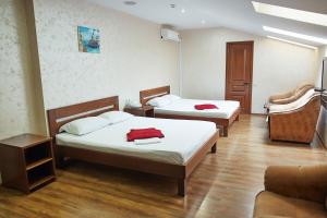 a hotel room with two beds and a couch at Mini Otel Spokoyny Otdyh in Stavropol