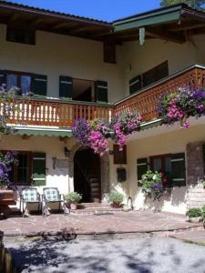 a house with flowers hanging from a balcony at Haus Hirschpoint Ferienwohnungen in Ramsau