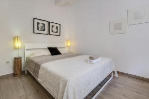 a bedroom with a large bed with two lamps at Apartamento Planta Baja in Los Abrigos