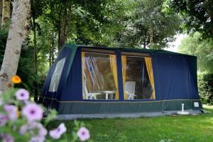 une tente bleue et verte dans l'herbe dans l'établissement Camping Bella Sardinia, à S'archittu Cuglieri