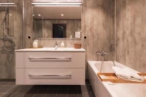 a bathroom with a sink and a tub and a mirror at Arctic Oasis Haven in Pettvik +40 photos