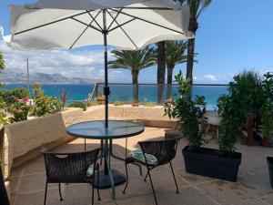 stół i krzesła z parasolem i oceanem w obiekcie Appartement Albimar w mieście Albir
