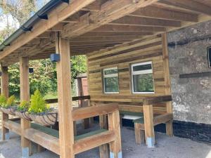 a wooden pavilion with benches outside of a house at Kestor Inn in Newton Abbot