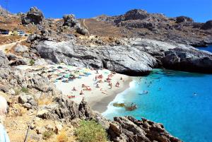 Un grupo de personas en una playa en el agua. en Afroditi Traditional Villa, en Yiannioú