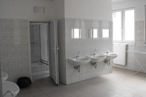 ein Bad mit 3 Waschbecken und einer Dusche in der Unterkunft Pannonia Hostel in Budapest