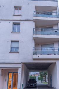 a white building with a car parked in front of it at Le Clos Jaurès/Lyon-Eurexpo/Parc OL in Décines-Charpieu