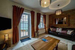 ein Wohnzimmer mit Sofa und Tisch in der Unterkunft Stay in our beautiful 1850’s Coastguards Cottage. in Felpham