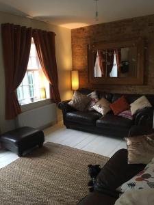 ein Wohnzimmer mit einem Sofa und einem Hund auf dem Boden in der Unterkunft Stay in our beautiful 1850’s Coastguards Cottage. in Felpham