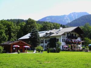 ein großes Haus auf einem grünen Rasen in der Unterkunft Gästehaus Siegllehen in Schönau am Königssee