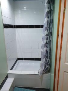 a bath tub with a shower curtain in a bathroom at Foxhall Village Guest House in Blackpool