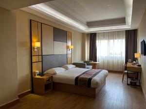 a hotel room with a bed and a desk at 2000 Hotel Downtown Kigali in Kigali