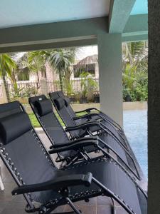 - un ensemble de chaises noires assises sur une terrasse dans l'établissement Neville's Villa - Pet friendly with Pool, à Alibaug