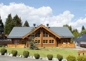 a large wooden house with a gambrel roof at Vakantiehuis Luxe Blokhuis B in Willingen