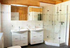 a bathroom with two sinks and a shower at Luxus Blockhaus Willingen Sonnenhang Lodge B in Willingen +17 photos