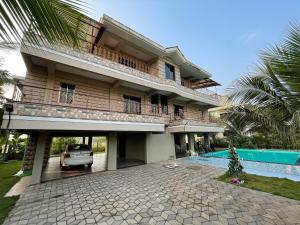 a house with a car parked in front of it at Neville's Villa - Pet friendly with Pool in Alibaug
