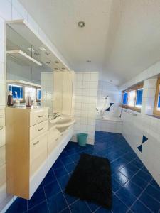 a large bathroom with a sink and a mirror at Hugo - der Bodenständige - Huusa im Bregenzerwald in Rehmen