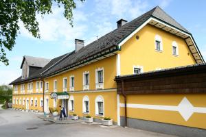 um edifício amarelo com uma seta branca em Hotel Traunfall em Viecht