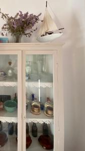 a white cabinet with dishes and a boat on it at Astra Serifos in Livadion