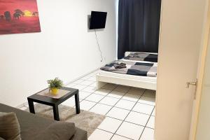ein Wohnzimmer mit einem Bett und einem Tisch in der Unterkunft Ferienwohnung Köln Junkersdorf in Köln