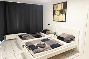 2 camas en una habitación con cortinas negras en Ferienwohnung Köln Junkersdorf, en Colonia