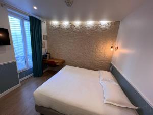 A bed or beds in a room at Hôtel Tilde