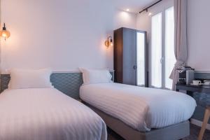 A bed or beds in a room at Hôtel Tilde