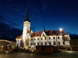 een groot wit gebouw met 's nachts een klokkentoren bij Hotel Alfréd a Hermína in Olomouc