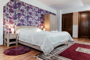 una camera da letto con un letto grande con carta da parati floreale di Casa Marta a Sîmbăta de Sus