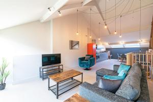 a living room with a couch and a tv at Carriage Works by Guestz in Preston