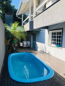 a blue swimming pool in front of a house at Residencia da Kel in Bombinhas