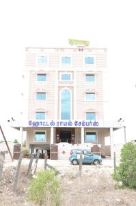 a building with a car parked in front of it at Hotel Royal Chambers in Coimbatore