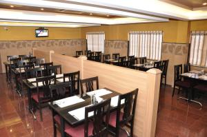 a restaurant with tables and chairs and a bar at Hotel Royal Chambers in Coimbatore