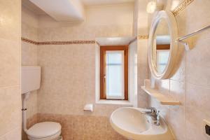 La salle de bains est pourvue d'un lavabo, de toilettes et d'un miroir. dans l'établissement Appartamenti Gg 3, à Livigno