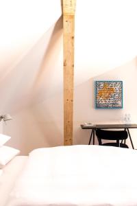 a bedroom with a bed and a desk with a table at Kai 36 - Hotel zwischen Fels und Fluss in Graz