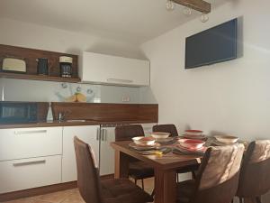 een keuken met een houten tafel met stoelen bij Apartments Skok in Bled +17 foto's